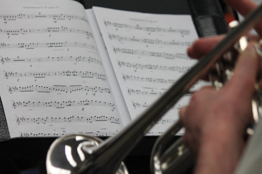 A trumpet in front of sheet music