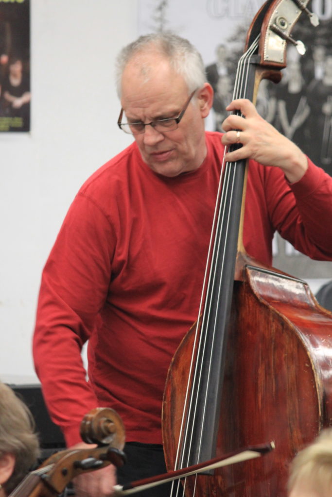 An older man playing the string bass