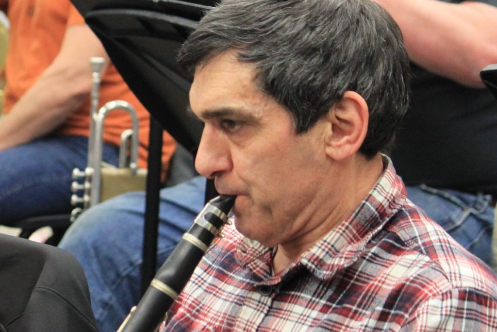 Close up of an older man playing the clarinet during a concert