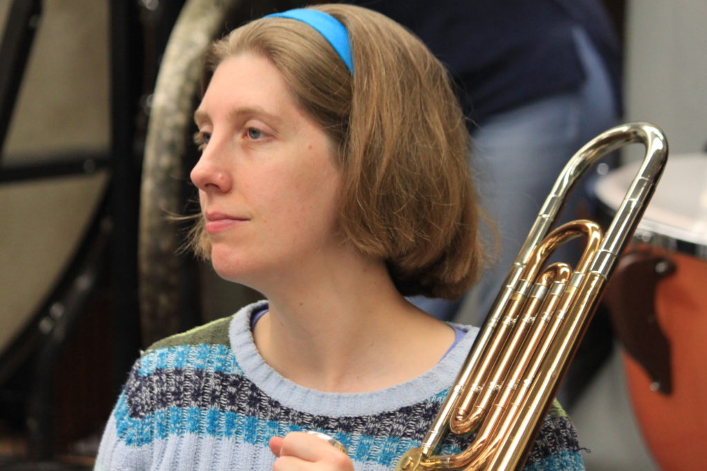 A woman holding a brass instrument