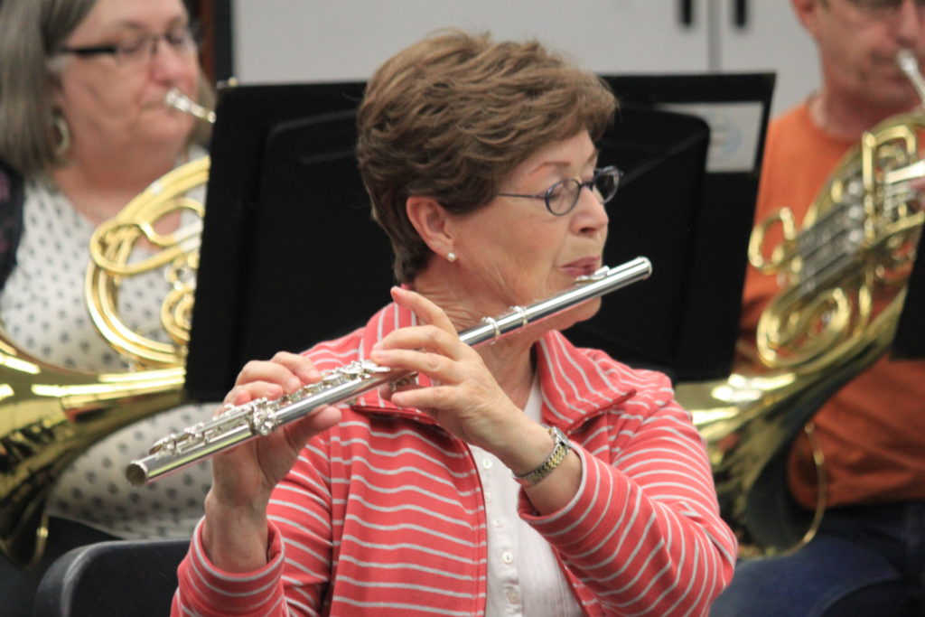 An older woman playing a flute